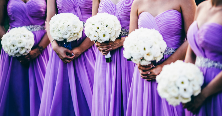 Line of bridesmaids in sleeveless dresses
