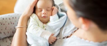 A woman holds a sleeping baby
