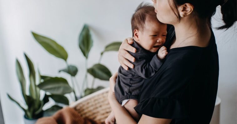 A mom holds a crying baby