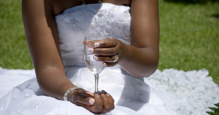 Bride holding a champagne glass filled with water