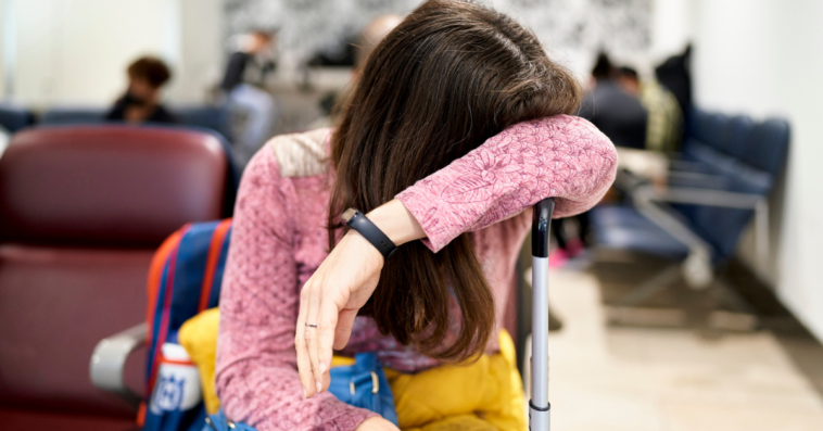 Woman crying over suitcase in waiting room.