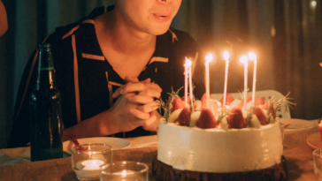 Teen boy blowing out birthday candles.