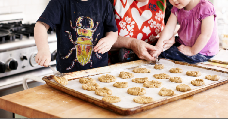 Grandmother baking cookies with grandchildren.