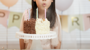 little girl blowing out birthday candles.