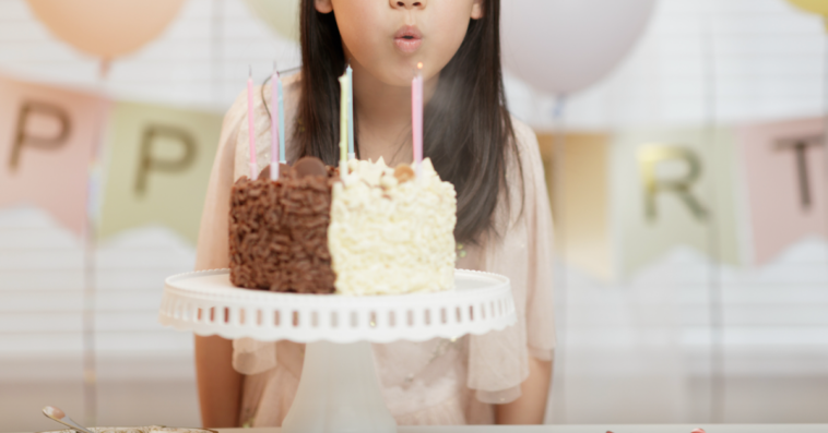 little girl blowing out birthday candles.