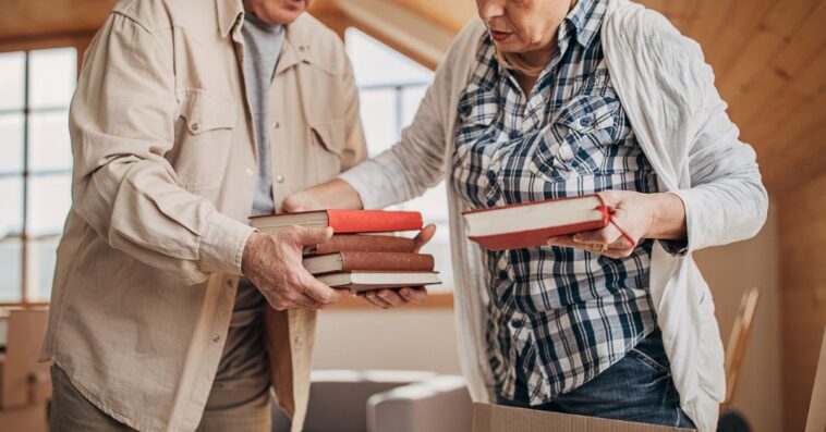 An older couple packs up a box