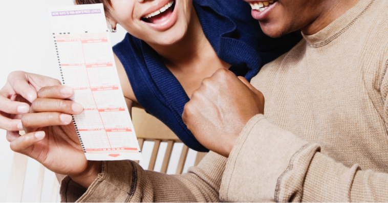 Couple holding lottery ticket.
