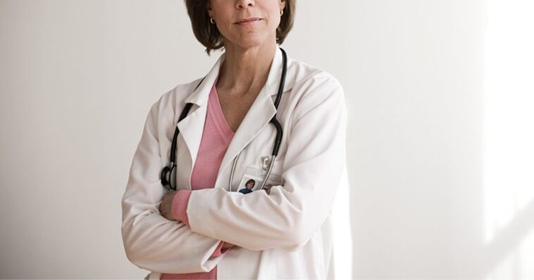 A female doctor stands with her arms crossed