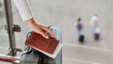 Woman holding passport and suitcase