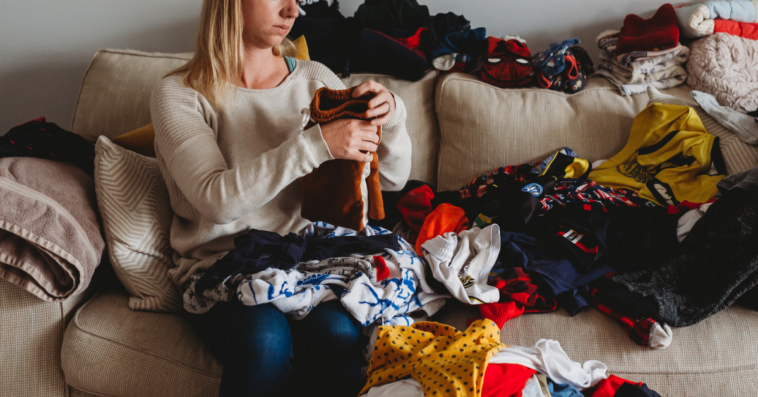 Woman unhappily folding laundry