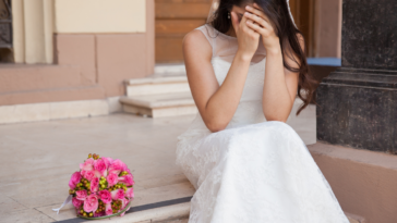 A crying bride with her head in her hands.