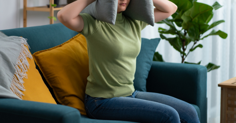 enraged woman with pillow over her head.