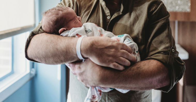 man holding newborn baby