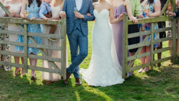 family wedding portrait by a rustic wooden fence