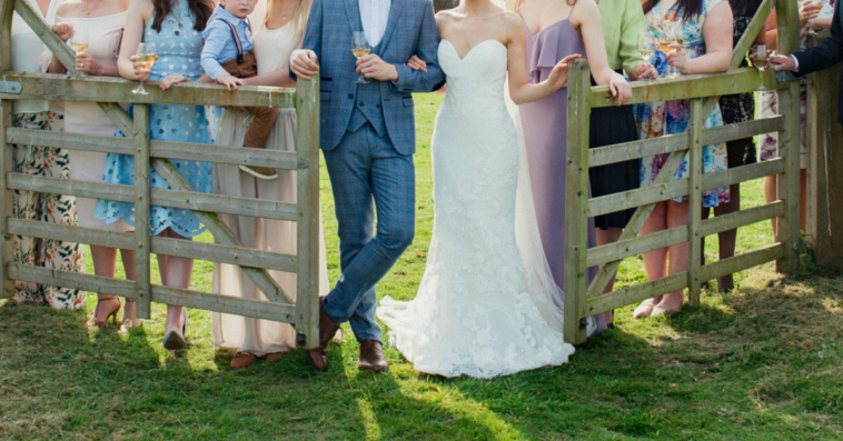 family wedding portrait by a rustic wooden fence
