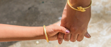 mother and daughter holding hands wearing gold gelang