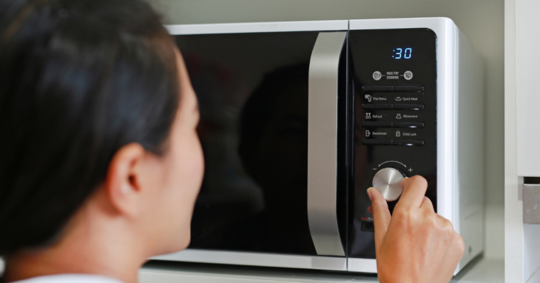 Asian woman using microwave