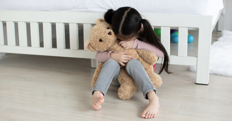 little girl crying over a teddy bear