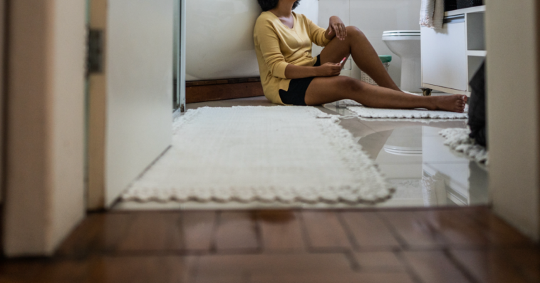 Woman leaning against a bathtub.