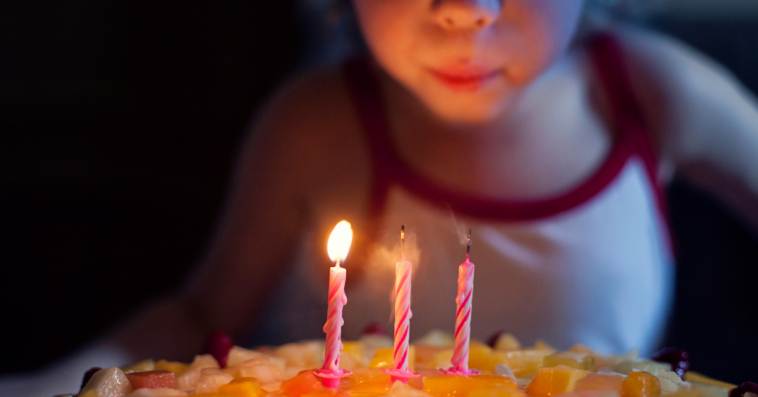 Girl making wish on birthday candles