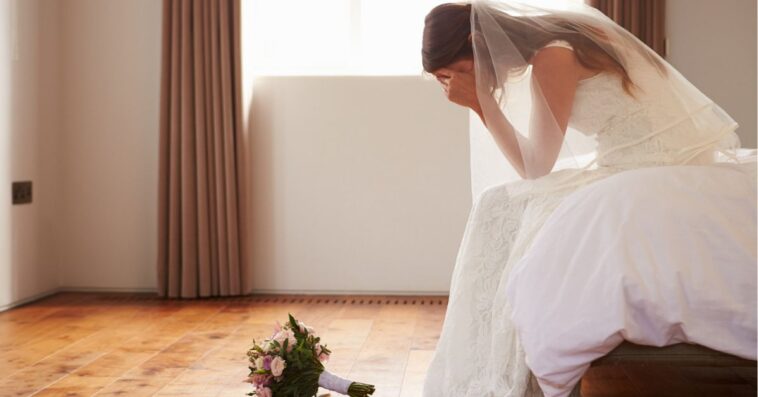 Bride In bedroom with her hands in her hands, her bouquet on the floor