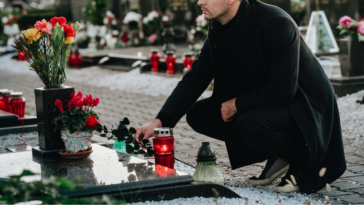 Young man visiting late friend at grave