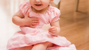 Baby in pink dress at wedding