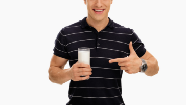 man pointing to a glass of milk he's holding