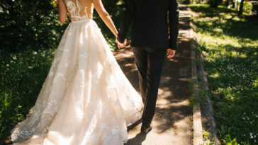 bride and groom walking down path holding hands