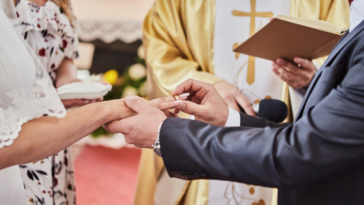 couple exchange rings during a Catholic wedding
