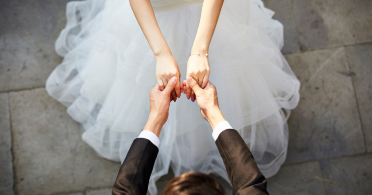 a bride holds hands with a man in a tuxedo