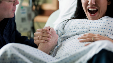 woman in labor with her husband holding her hand