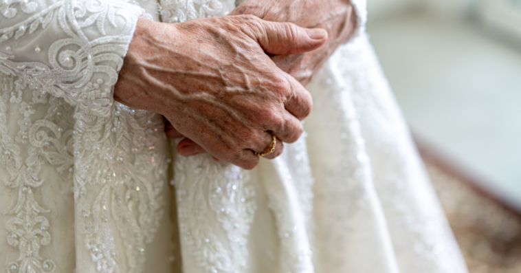 Elderly bride with her hands clasped.