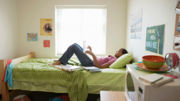 Girl lying on her bed in a college dorm.