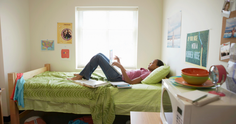 Girl lying on her bed in a college dorm.