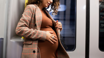 Pregnant woman standing on a train