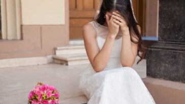 Hopeless bride crying outside a church.