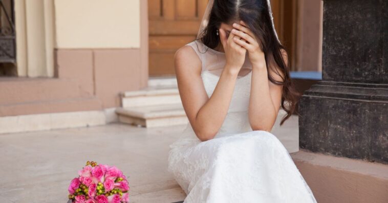 Hopeless bride crying outside a church.
