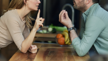 a man and woman argue in a kitchen