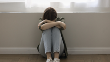 Teenage girl crying in a hallway.