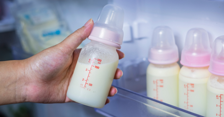 Person holding a bottle of breast milk