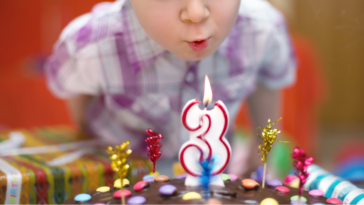 Young boy blowing out his birthday candles