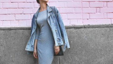 Woman wearing an elegant dress and a jean jacket.