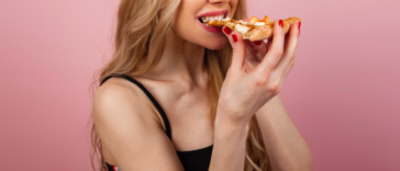 Woman eating a slice of pizza.