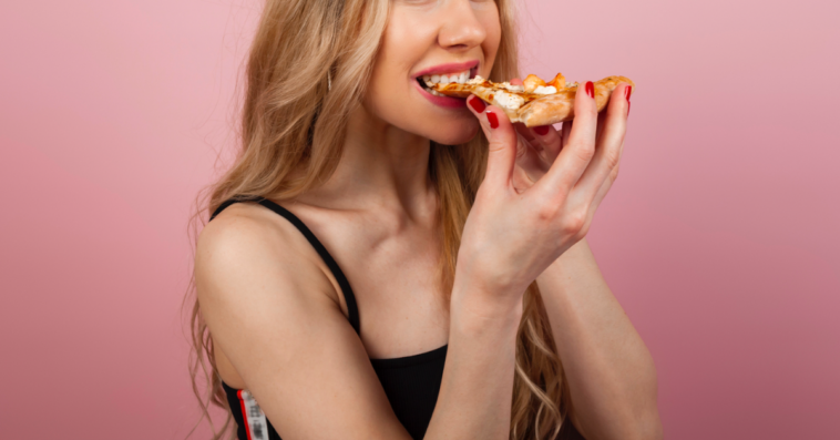 Woman eating a slice of pizza.