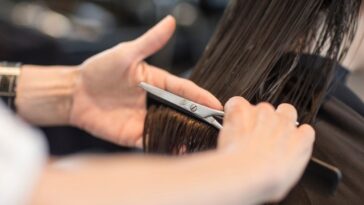 Hairdresser cutting hair of customer