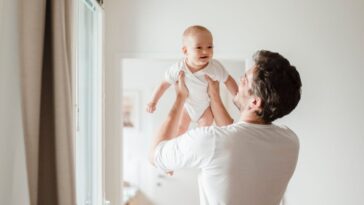 Father holding baby girl at home