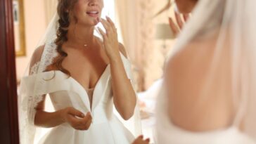 illustrative pictures of wedding - a young bride adjusting her makeup in front of the mirror