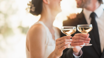 Bride and groom clinking champagne glasses.