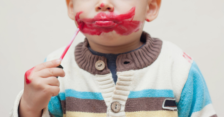 Little boy playing with makeup